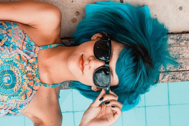 femme au cheveux bleus avec des lunettes de soleil