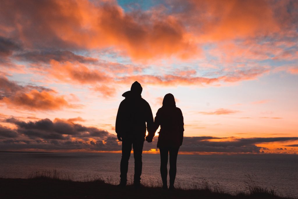 couple regardant au loin un coucher de soleil