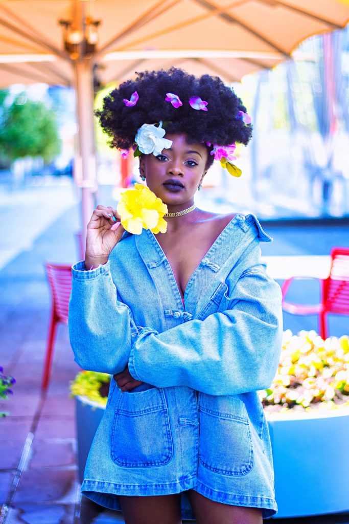 Jeune femme en chemise en jean et fleur dans les cheveux