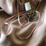 mètre de couture et ciseau sur un drap en soie
